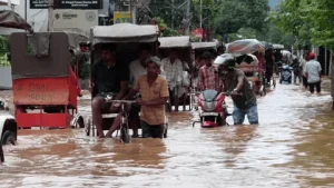 ভারী বৃষ্টির কারণে আসামের গৌহাটিতে রাস্তায় জমে থাকা পানিতে যানবাহন চলাচল করছে।